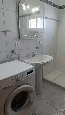 a bathroom with a washing machine and a sink at Cozy Private Apartment Calheta in Arco da Calheta