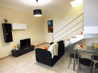 a living room with a table and a dining room at Cozy Private Apartment Calheta in Arco da Calheta