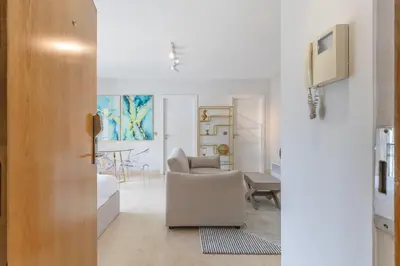 a white living room with a chair and a table at Home Funchal Personal 3 in Funchal