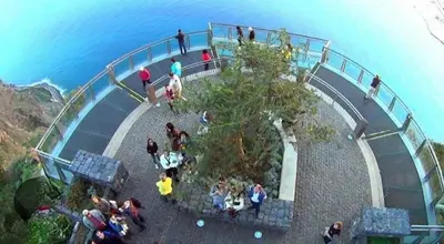 a group of people standing on a walkway near the water at Home Funchal Personal 3 in Funchal