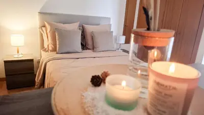 a room with a bed with two candles on a table at Mãe de Deus - Caniço - Madeira in Caniço