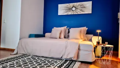 a bedroom with a bed with a blue wall at Mãe de Deus - Caniço - Madeira in Caniço