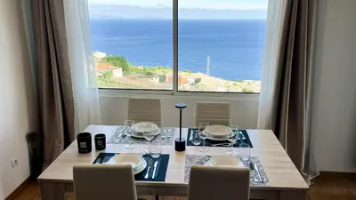 a dining room table with a view of the ocean at Mãe de Deus - Caniço - Madeira in Caniço