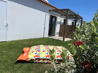 a blanket laying on the grass in front of a house at Casa Tonel in Bordeira