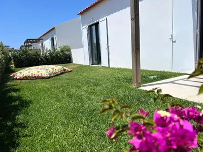 a garden with pink flowers in the grass at Casa Tonel in Bordeira