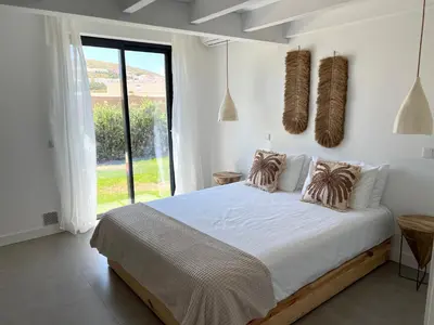 a white bedroom with a large bed and a window at Casa Tonel in Bordeira