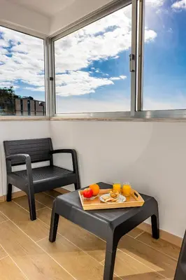 a room with a table and a chair and window at Residential Camacho, By OP in Funchal