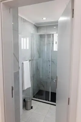 a bathroom with a shower with a glass door at Residential Camacho, By OP in Funchal