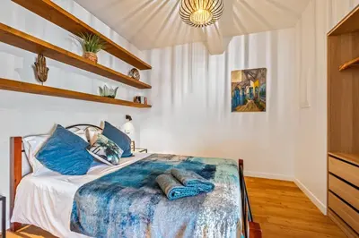 a bedroom with a bed with blue pillows on it at Larano in Funchal