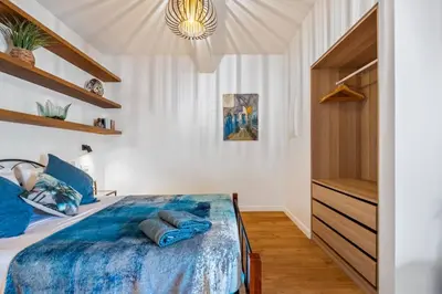 a bedroom with a bed with blue pillows on it at Larano in Funchal