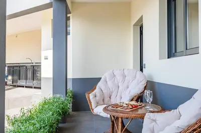 a wicker chair sitting on a porch with a table at Larano in Funchal