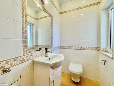 a bathroom with a sink and a toilet and a mirror at Casa Shani in Barão de São Miguel
