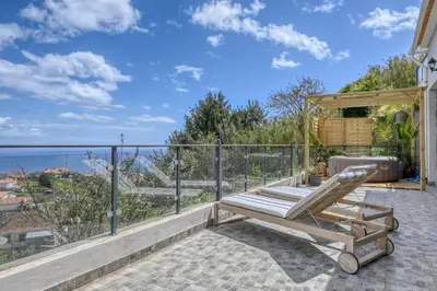 a patio with a bench and a view of the ocean at Valley Canhas I in Canhas