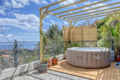 a hot tub on a deck with a pergola at Valley Canhas I in Canhas