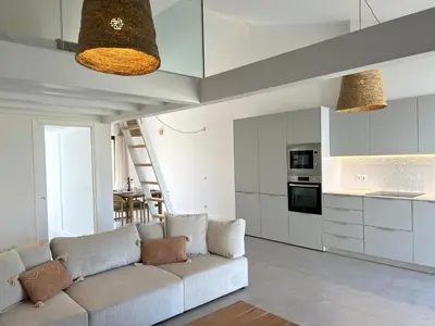 a living room with a couch and a kitchen at Casa Beliche in Aljezur