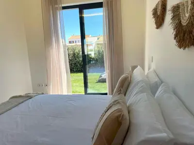 a bed in a room with a large window at Casa Telheiro in Aljezur
