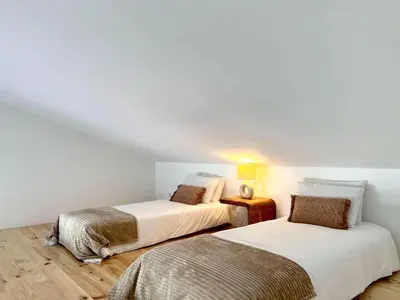 two beds in a room with white walls at Casa Telheiro in Aljezur
