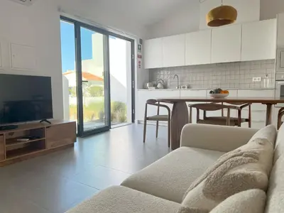 a kitchen and living room with a couch and a tv at Casa Telheiro in Aljezur