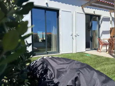 a house with sliding glass doors and a lawn at Casa Telheiro in Aljezur
