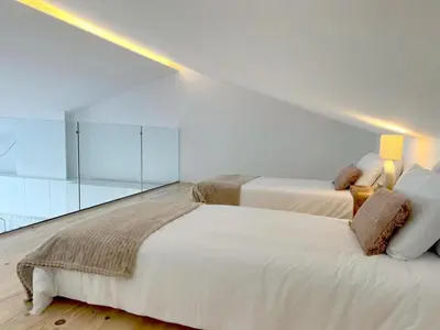 two beds in a white room with glass walls at Casa Telheiro in Aljezur