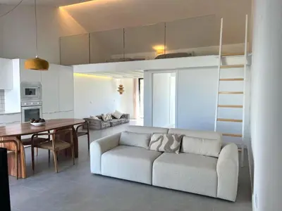 a living room and kitchen with a couch and a table at Casa Telheiro in Aljezur