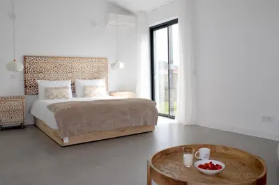 a bedroom with a bed and a table with a bowl of fruit at Casa Mareta in Bordeira