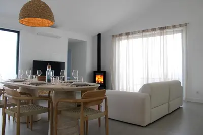 a living room with a table and a white couch at Casa Mareta in Bordeira