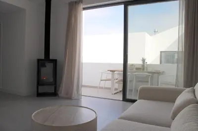 a living room with a couch and a fire place at Casa Mareta in Bordeira