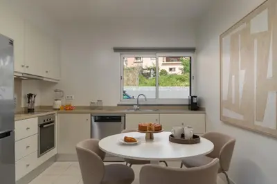 a kitchen with a table and chairs and a sink at Vila Venusta by An Island Apart in Calheta