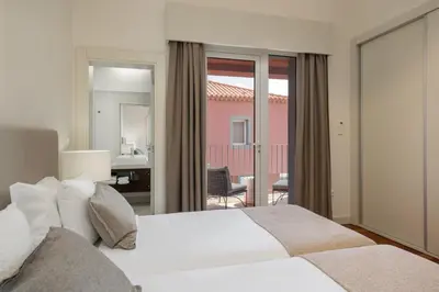 a bedroom with a large white bed and a balcony at Vila Venusta by An Island Apart in Calheta