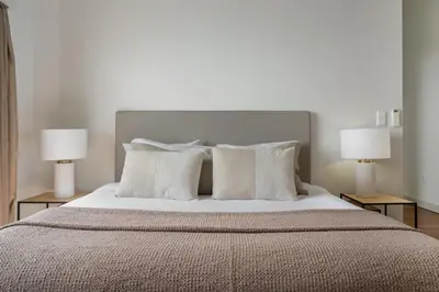 a bedroom with a bed with pillows and two lamps at Vila Venusta by An Island Apart in Calheta