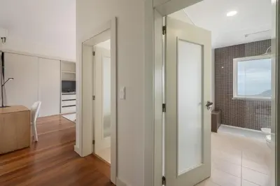 a bathroom with white walls and a glass door at Vila Venusta by An Island Apart in Calheta