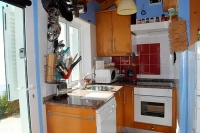 a small kitchen with a sink and a stove at Arrifana - CASA DAS MARÉS - Casa na Praia in Aljezur