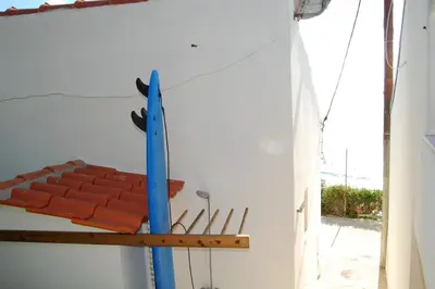 a bench with a blue surfboard on a wall at Arrifana - CASA DAS MARÉS - Casa na Praia in Aljezur