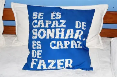 a blue pillow with the words se is carapa de sonker is car at Arrifana - CASA DAS MARÉS - Casa na Praia in Aljezur