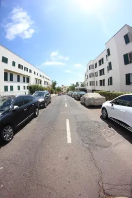 an empty parking lot with cars parked on the street at A Casa da Dúlia in Funchal
