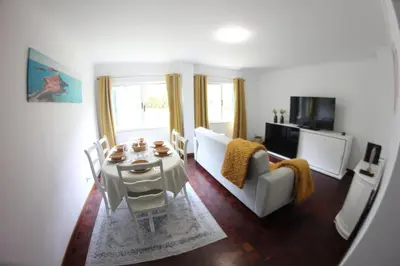 a living room with a white couch and a table at A Casa da Dúlia in Funchal