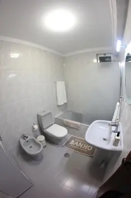 a bathroom with a white toilet and a sink at A Casa da Dúlia in Funchal