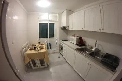 a small kitchen with a table and a sink at A Casa da Dúlia in Funchal