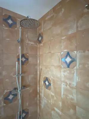 a bathroom with a shower with blue and brown tiles at Sunny Aljezur da Misericórdia, Aljezur, Costa Vicentina in Aljezur