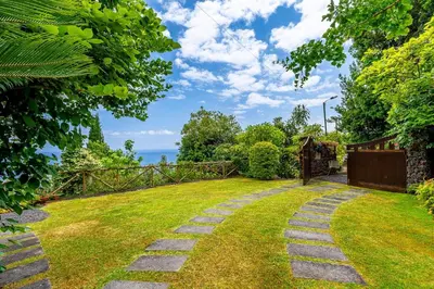 a garden with a stone walkway in the grass at Casa do Jardim Botanico in Faial