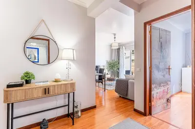 a living room with a mirror and a table at Cozy Stay in Caniço