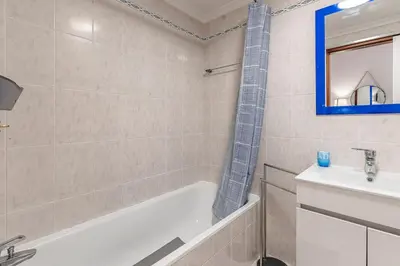 a bathroom with a tub and a sink at Cozy Stay in Caniço
