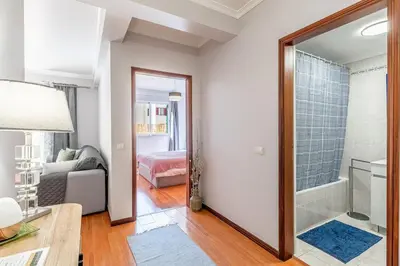a living room with a mirror and a bedroom at Cozy Stay in Caniço