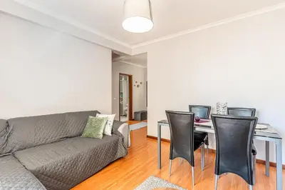 a living room with a couch and a table with chairs at Cozy Stay in Caniço