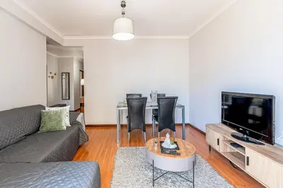 a living room with a couch and a table with a tv at Cozy Stay in Caniço