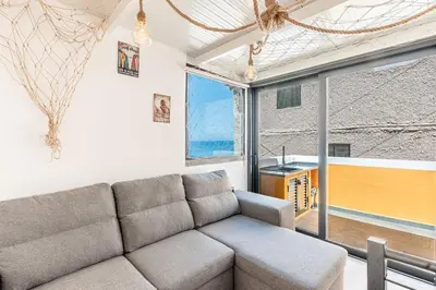 a living room with a couch and a large window at Yellow Wave in Paul do Mar