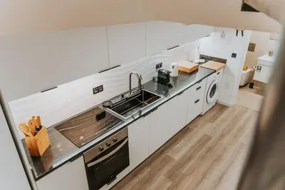 a white kitchen with a sink and a dishwasher at Yellow Wave in Paul do Mar
