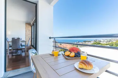 a table with a tray of fruit and juice on a balcony at Pena View Apartment by Atlantic Holiday in Funchal