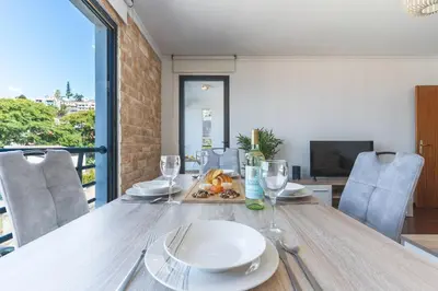 a table with a plate of food and wine glasses at Pena View Apartment by Atlantic Holiday in Funchal